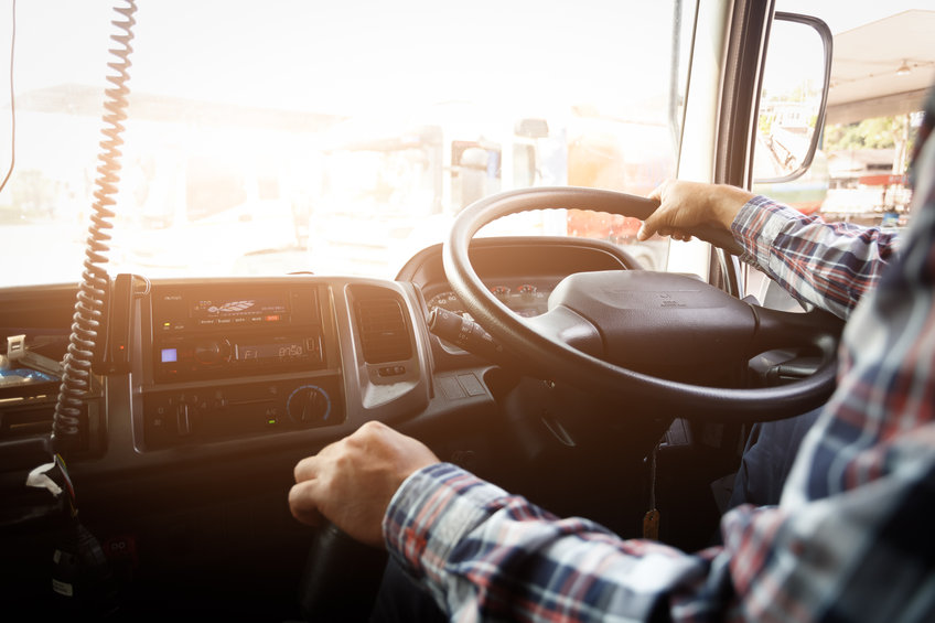 Fahrer am Lenkrad in LKW, mit Blick nach draußen